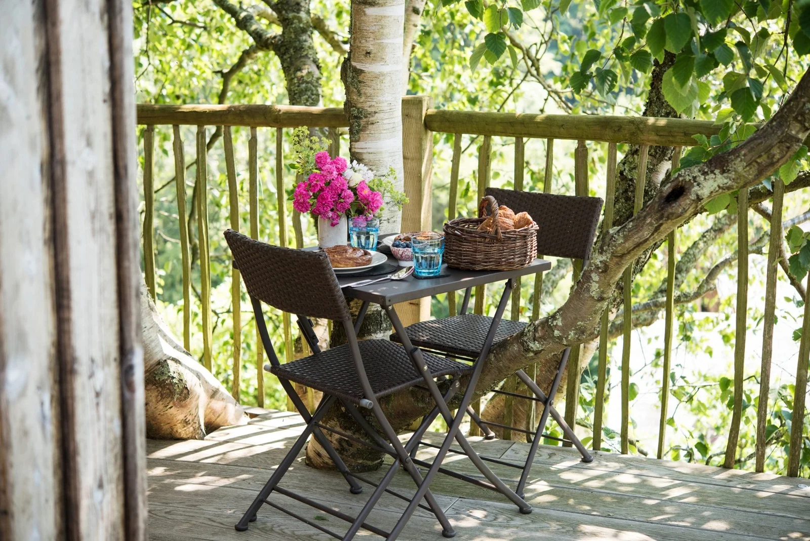 Table and chairs on the leafy treehouse deck