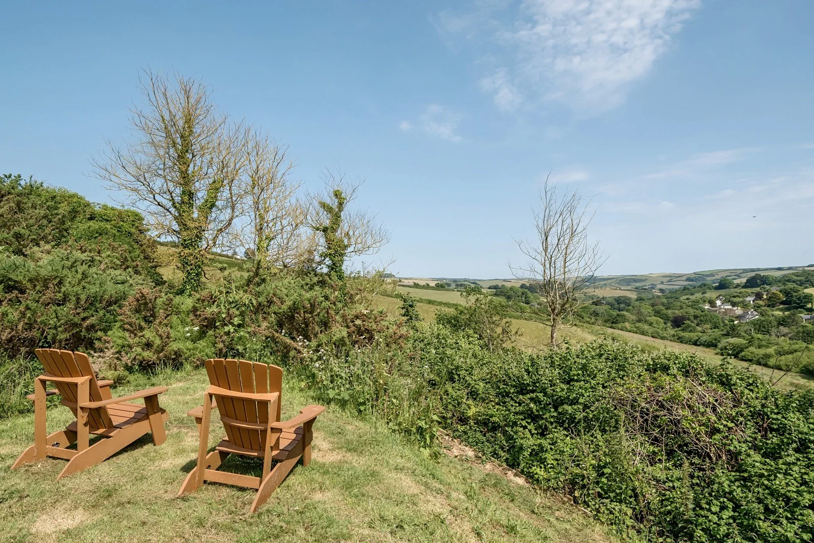 Two outdoor chairs looking across rolling green countryside