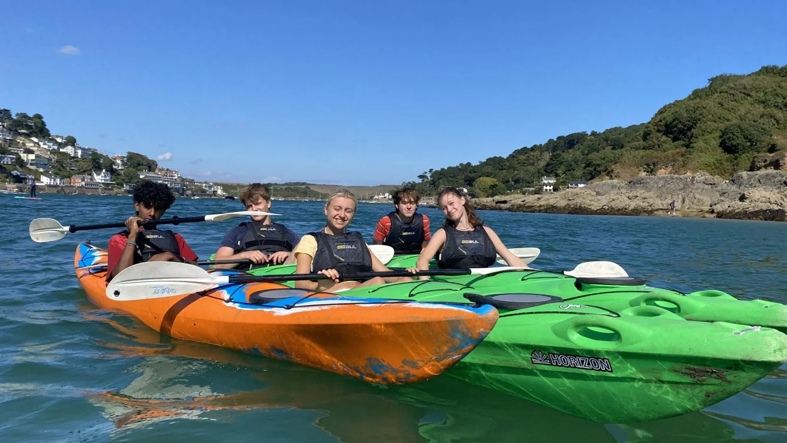 A group in bright tandem kayaks on the Salcombe estuary