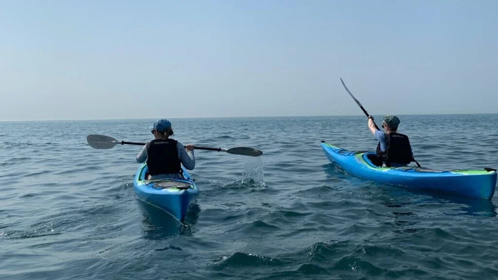 Two sea kayakers paddling in open water
