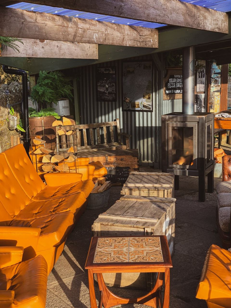 Bright yellow seating and timber tables in the School House garden