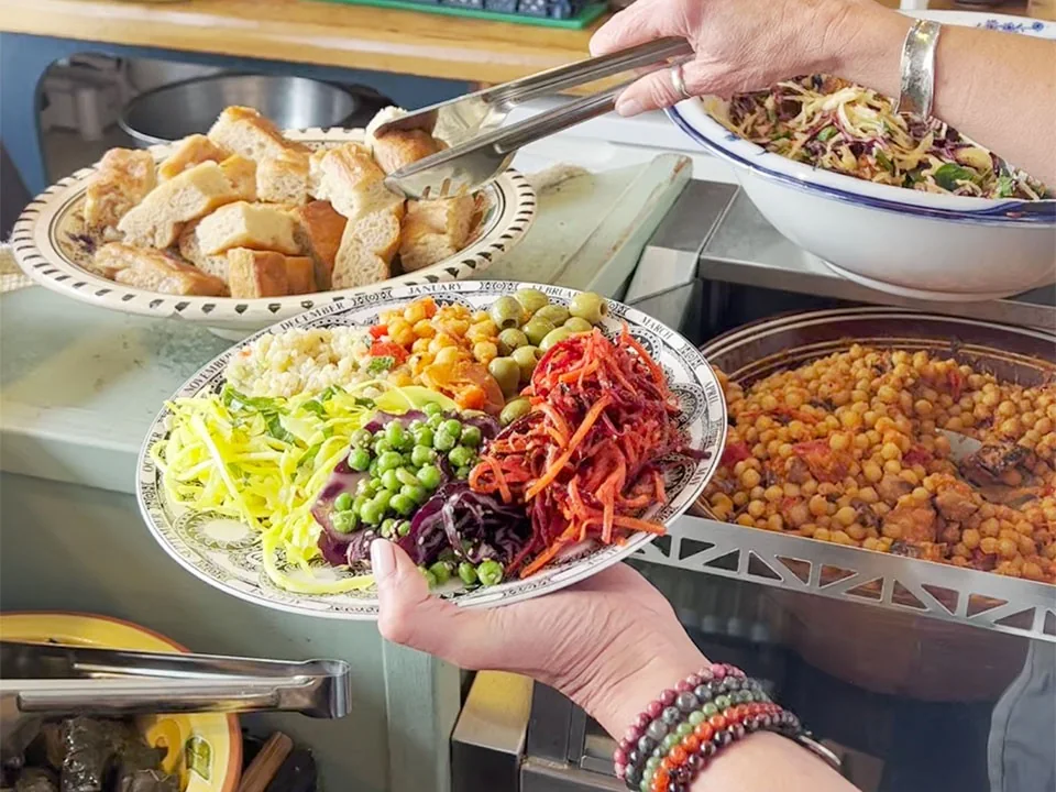 A guest filling a plate from the Seeds 2 Totnes buffet