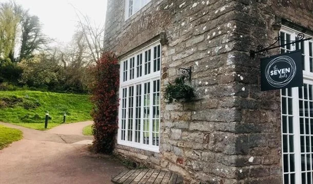 Stone exterior and Seven Dials sign at Cockington Court