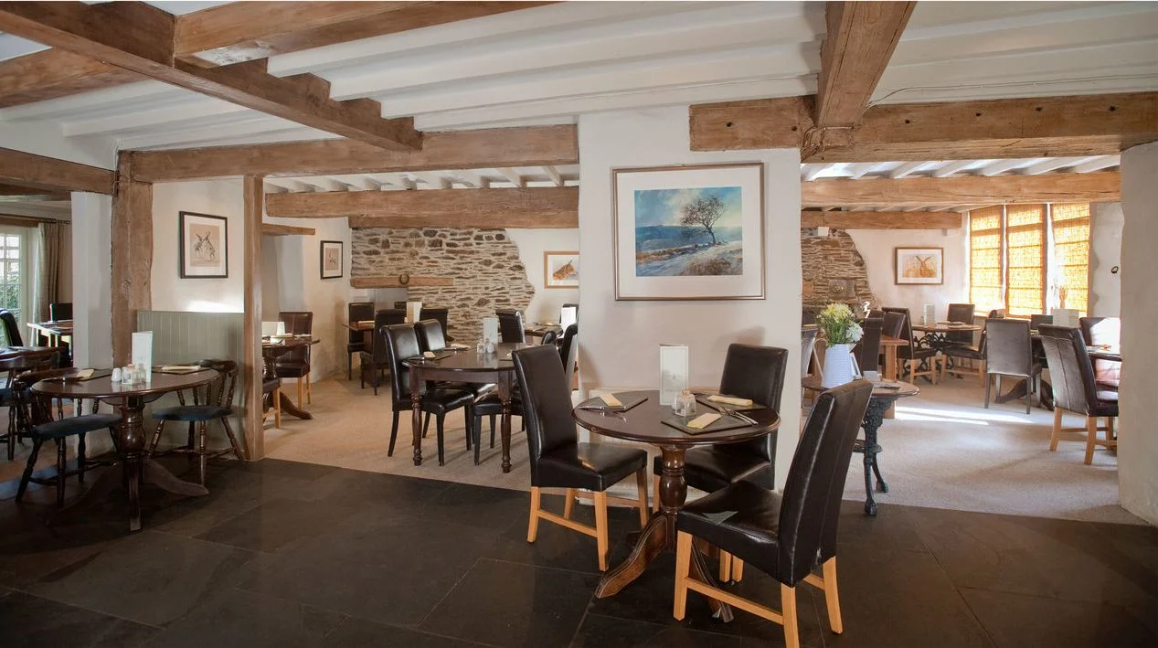 Light dining room with exposed beams and stonework at the Ship Inn