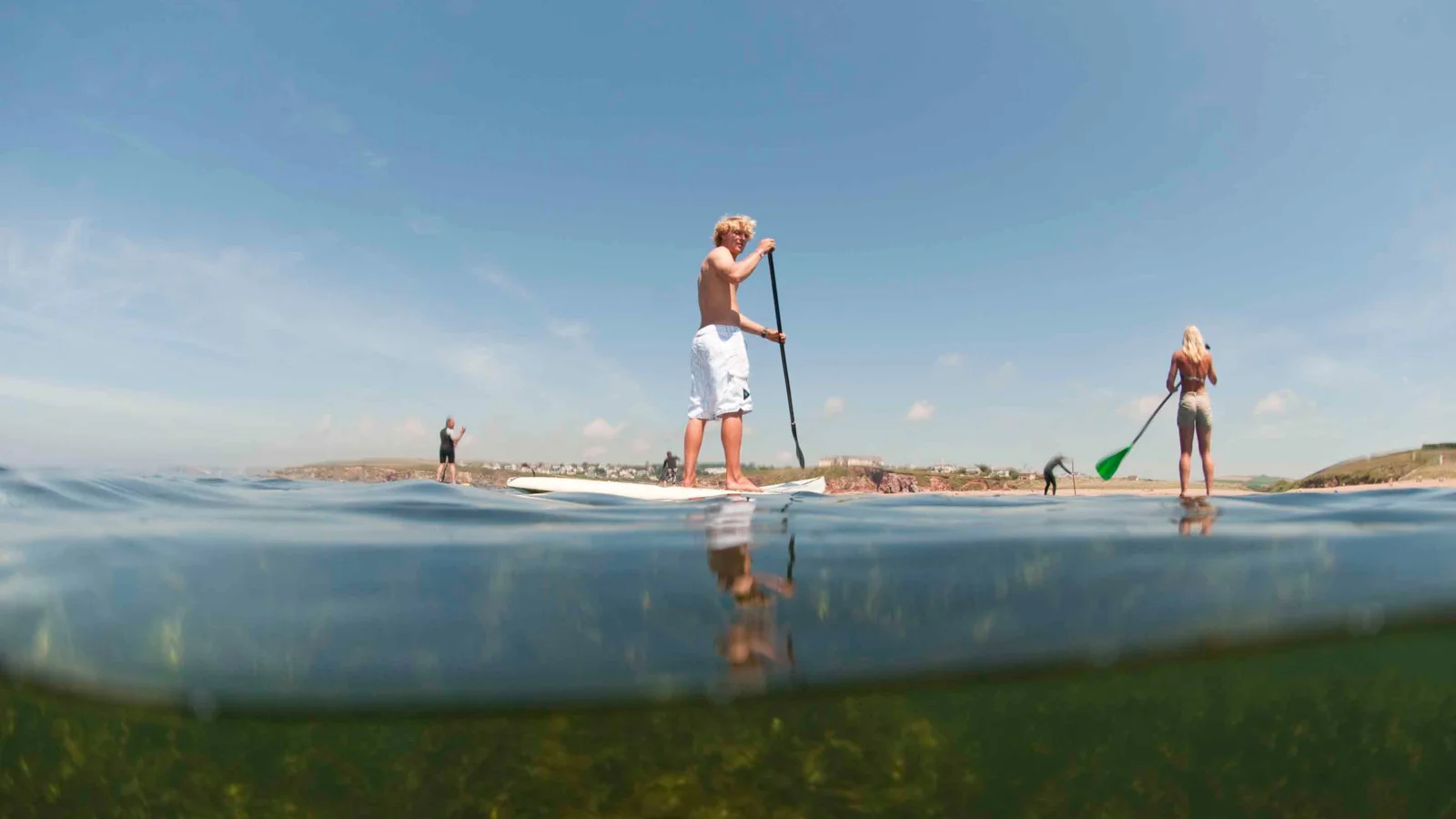 Paddleboarders viewed from water level near South Milton Sands