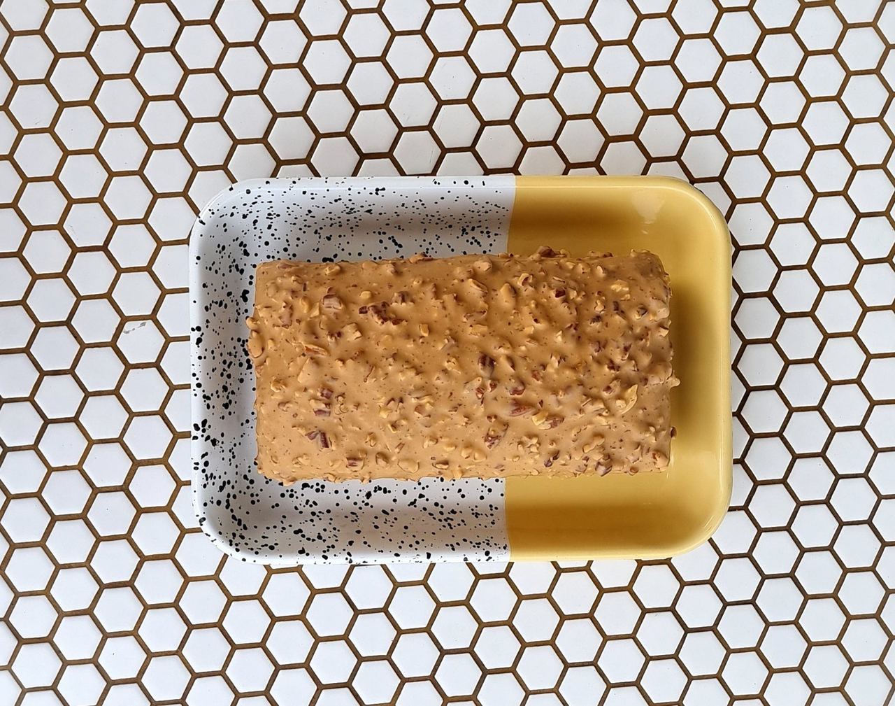 A golden baked dessert on a yellow rectangular dish