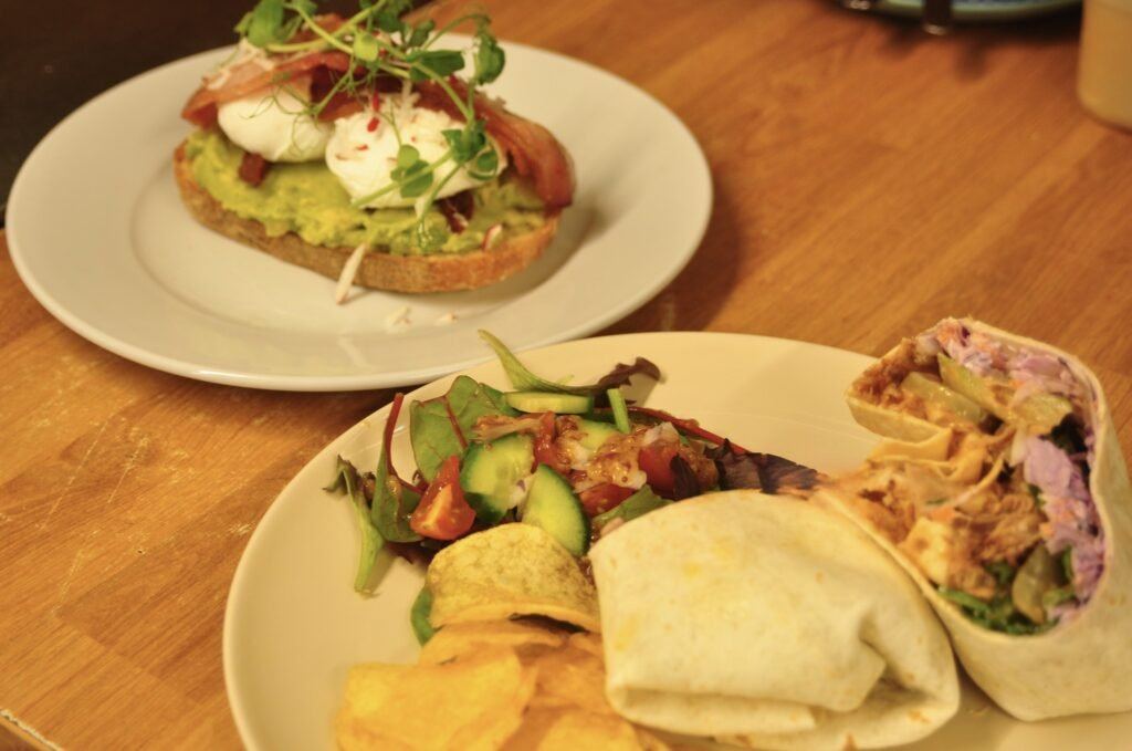 Two colourful lunch plates on a wooden café table