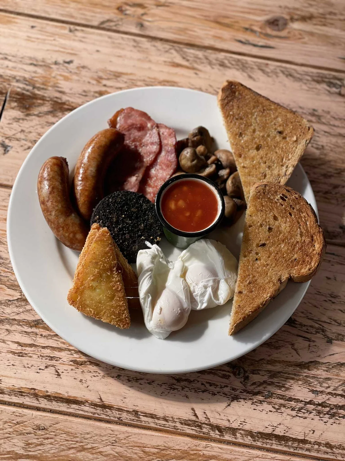 A cooked breakfast with toast on a wooden table