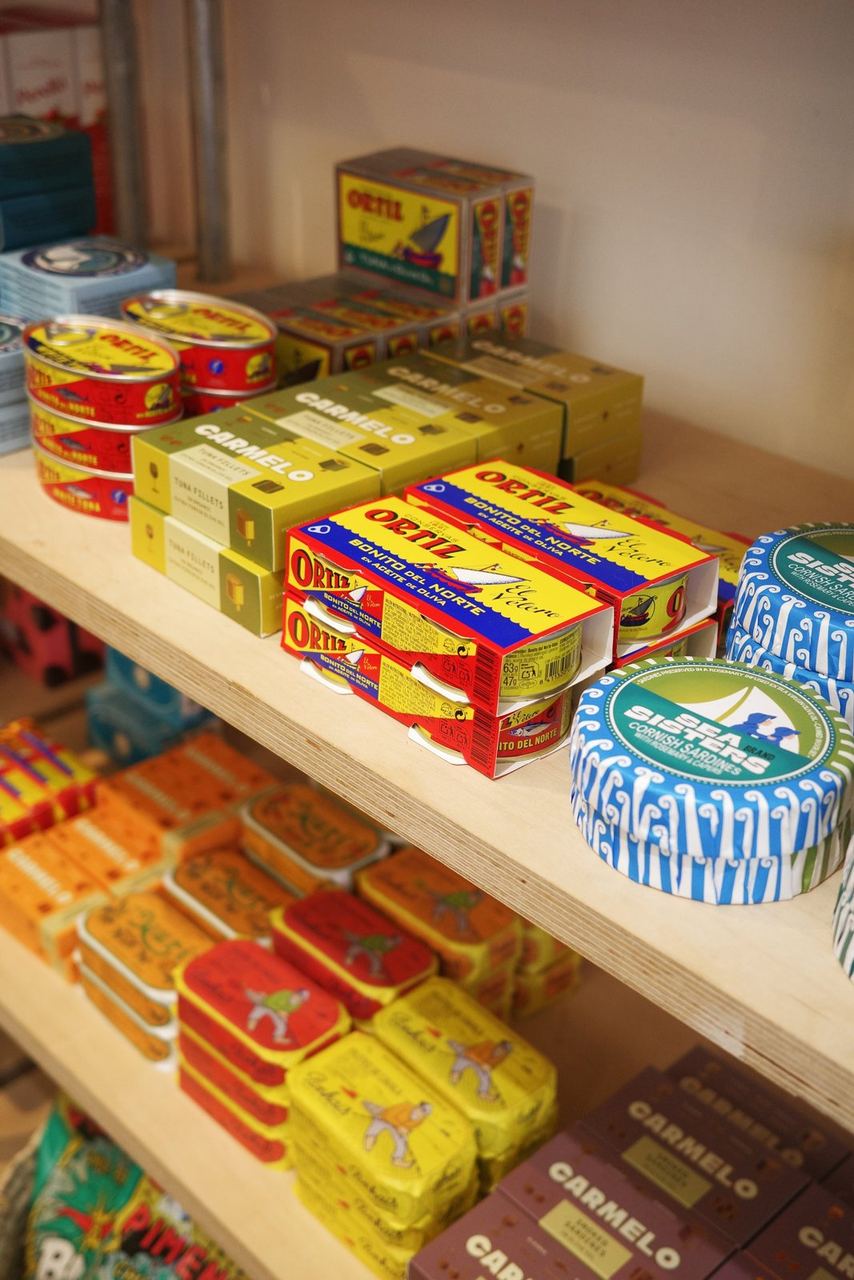 Brightly coloured tins and household goods on shop shelves