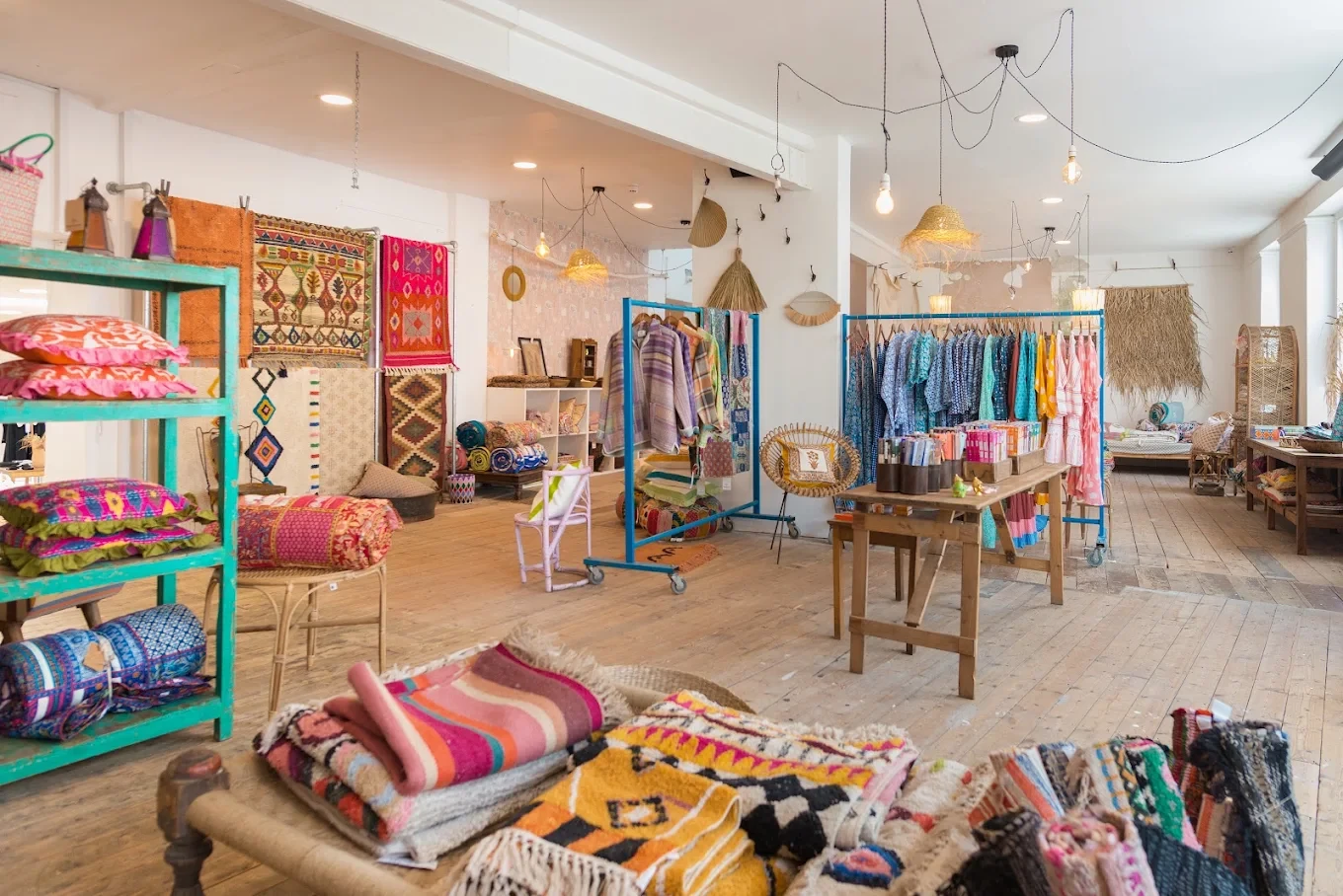 Colourful rugs, cushions and clothing displayed inside Sunshine & Snow