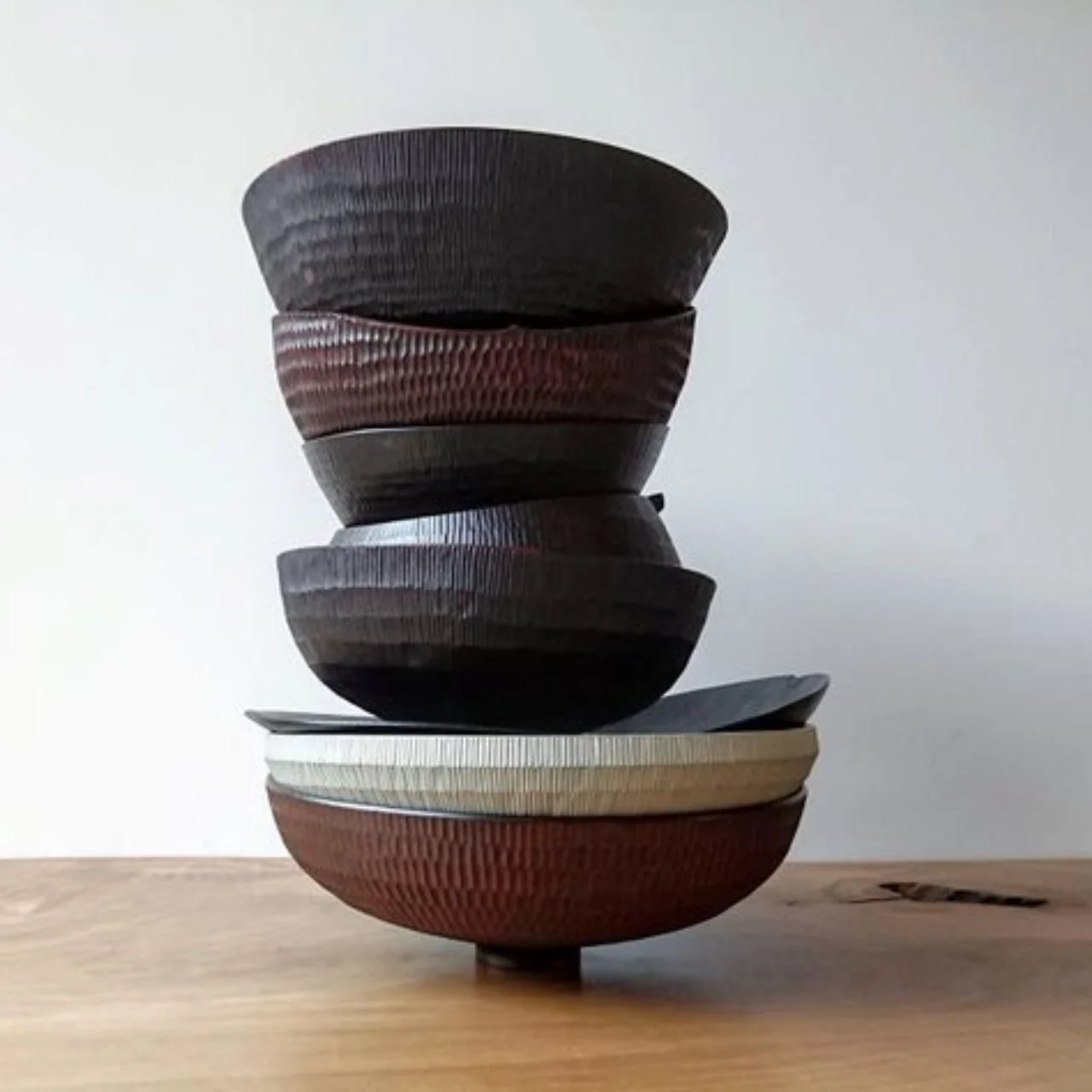 Stack of dark and pale handmade wooden bowls