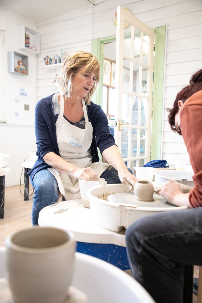 A pottery tutor and visitor in the bright rural studio