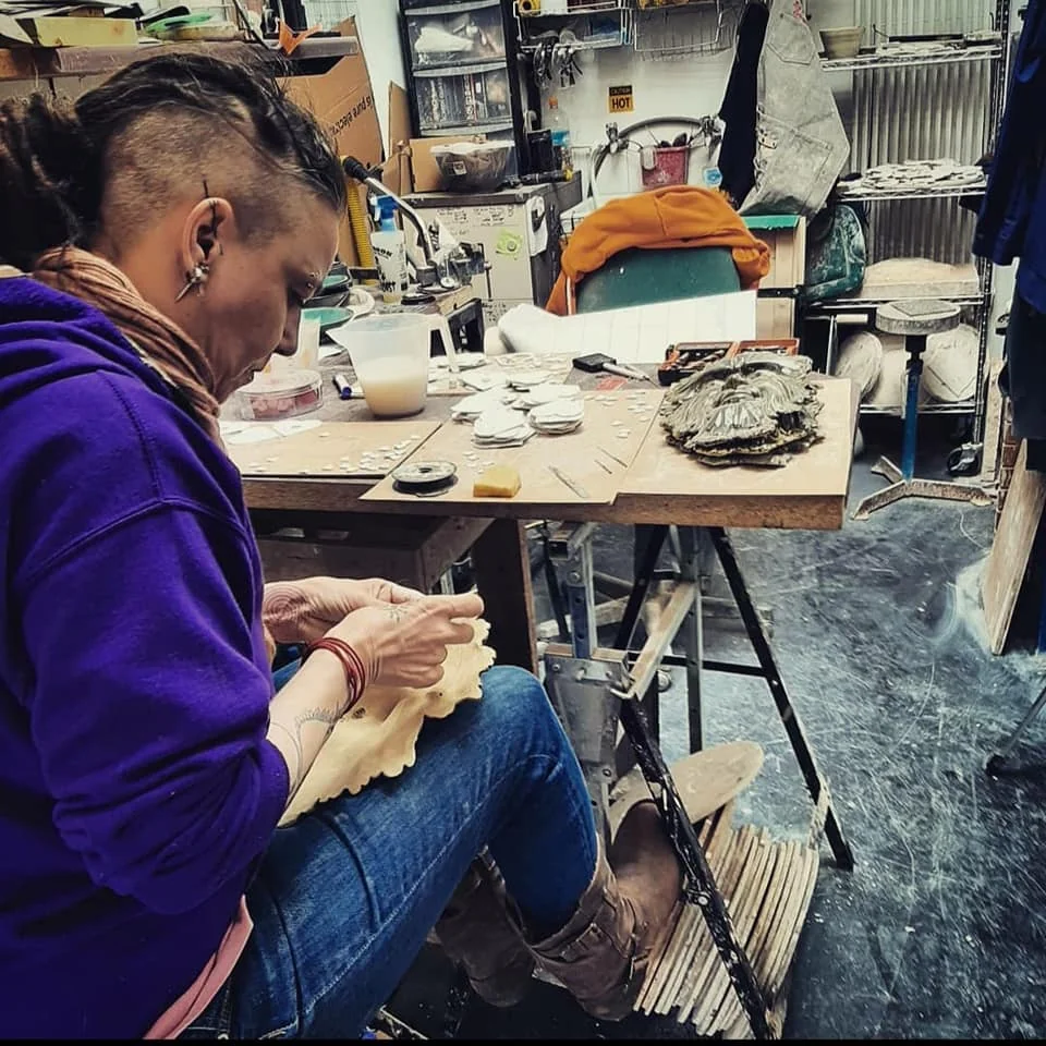 Tez working on pottery inside a busy ceramics studio