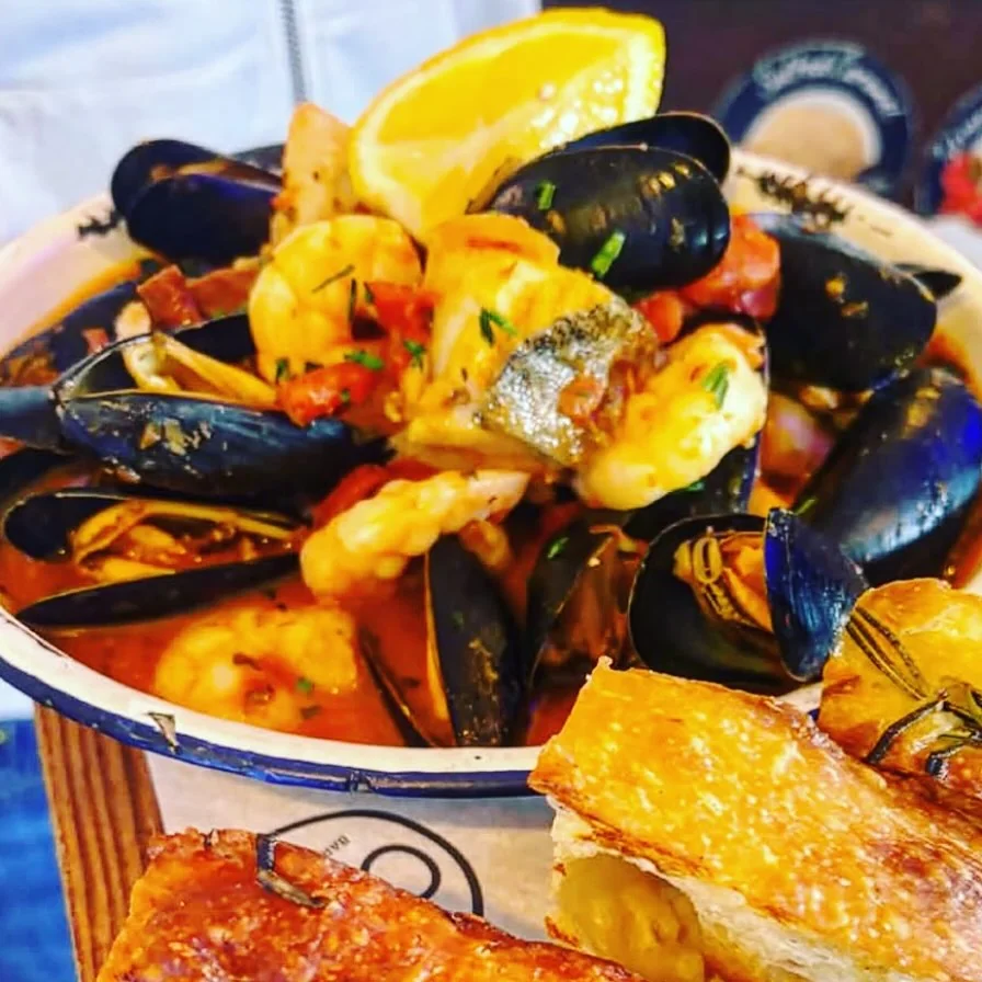 A bowl of shellfish and fish with lemon at The Cove