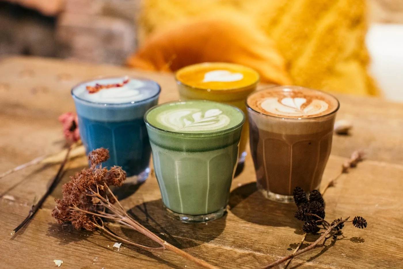 Colourful lattes on a wooden table at The Hairy Barista