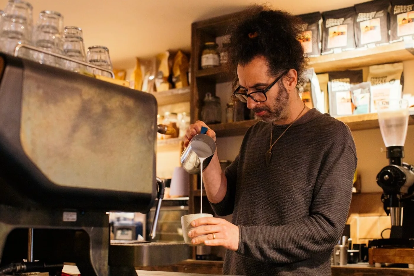 A barista pouring a drink at The Hairy Barista
