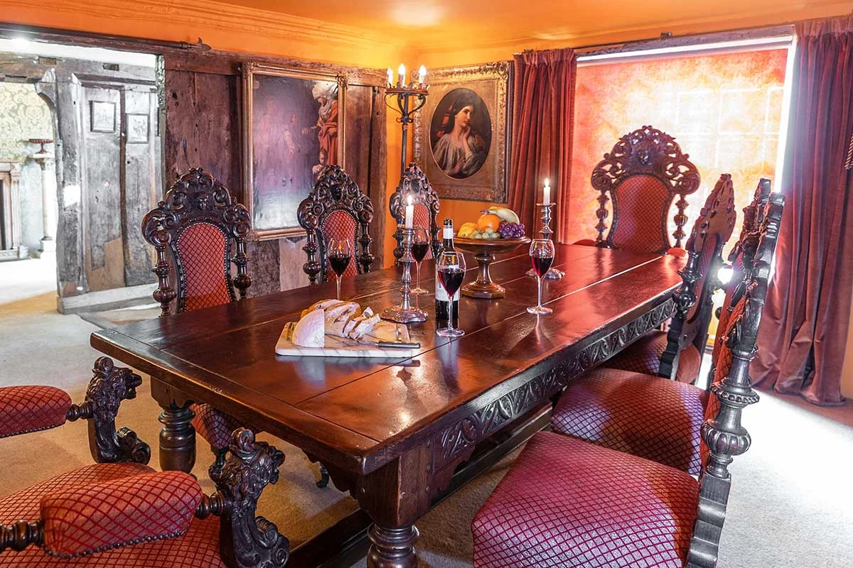 Carved chairs and a polished wooden dining table in the panelled dining room