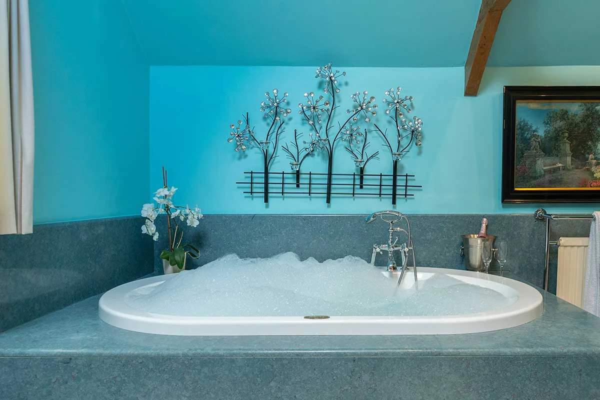 Large indoor Jacuzzi bath against a turquoise wall
