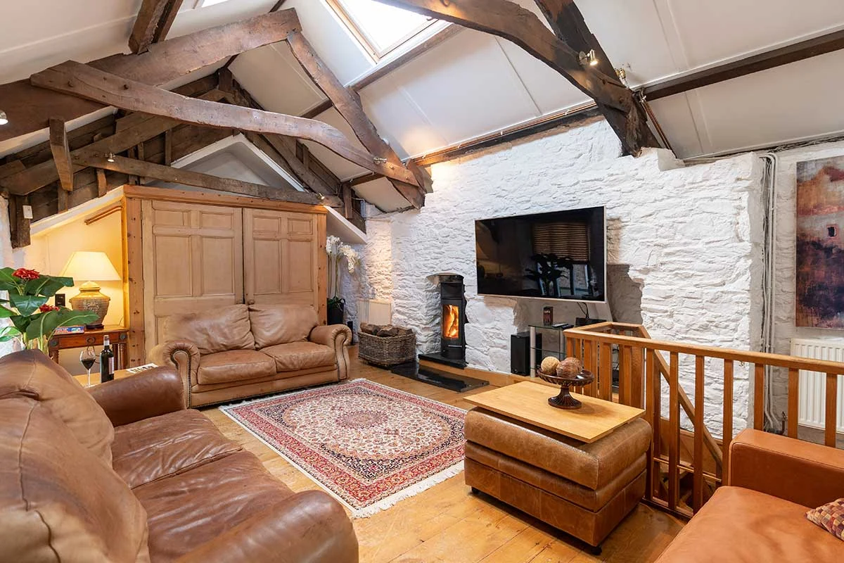 Leather sofas beneath a vaulted timber ceiling in the upper lounge