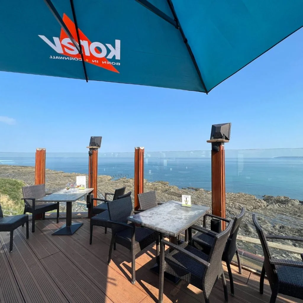 Decked Pier House terrace with tables looking across the sea
