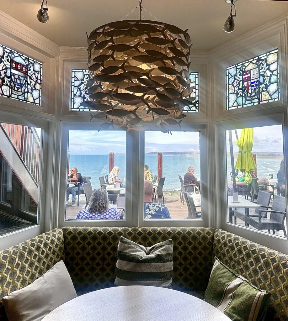 Curved green banquette and sculptural light in the Pier House bar
