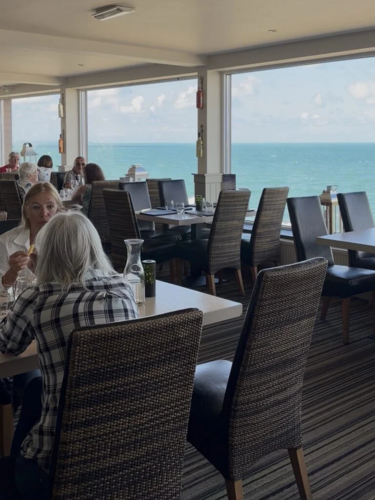 Pier House restaurant tables beside tall sea-facing windows
