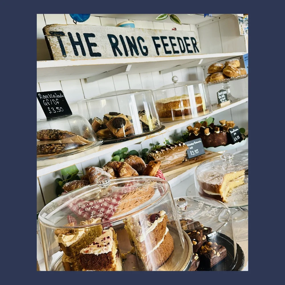 Cakes and pastries displayed beneath The Ring Feeder sign