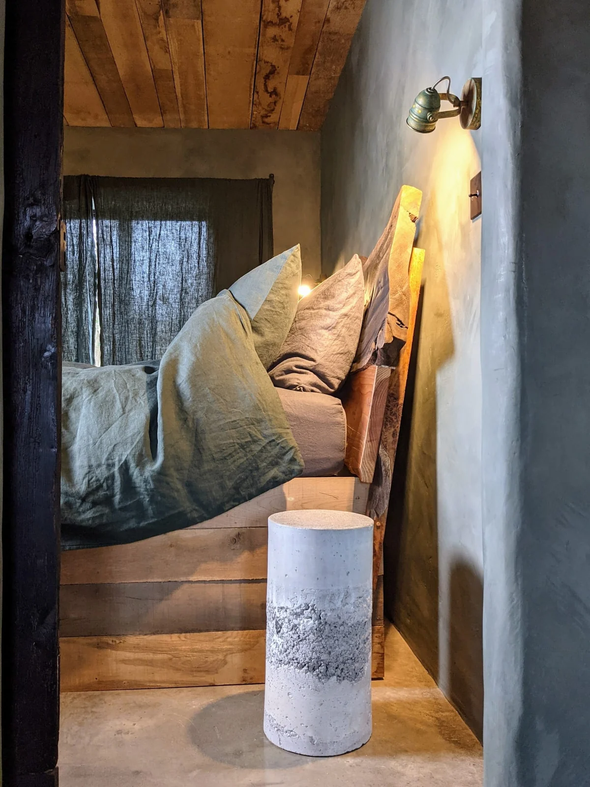 Cushioned reading nook with a warm lamp and wooden table