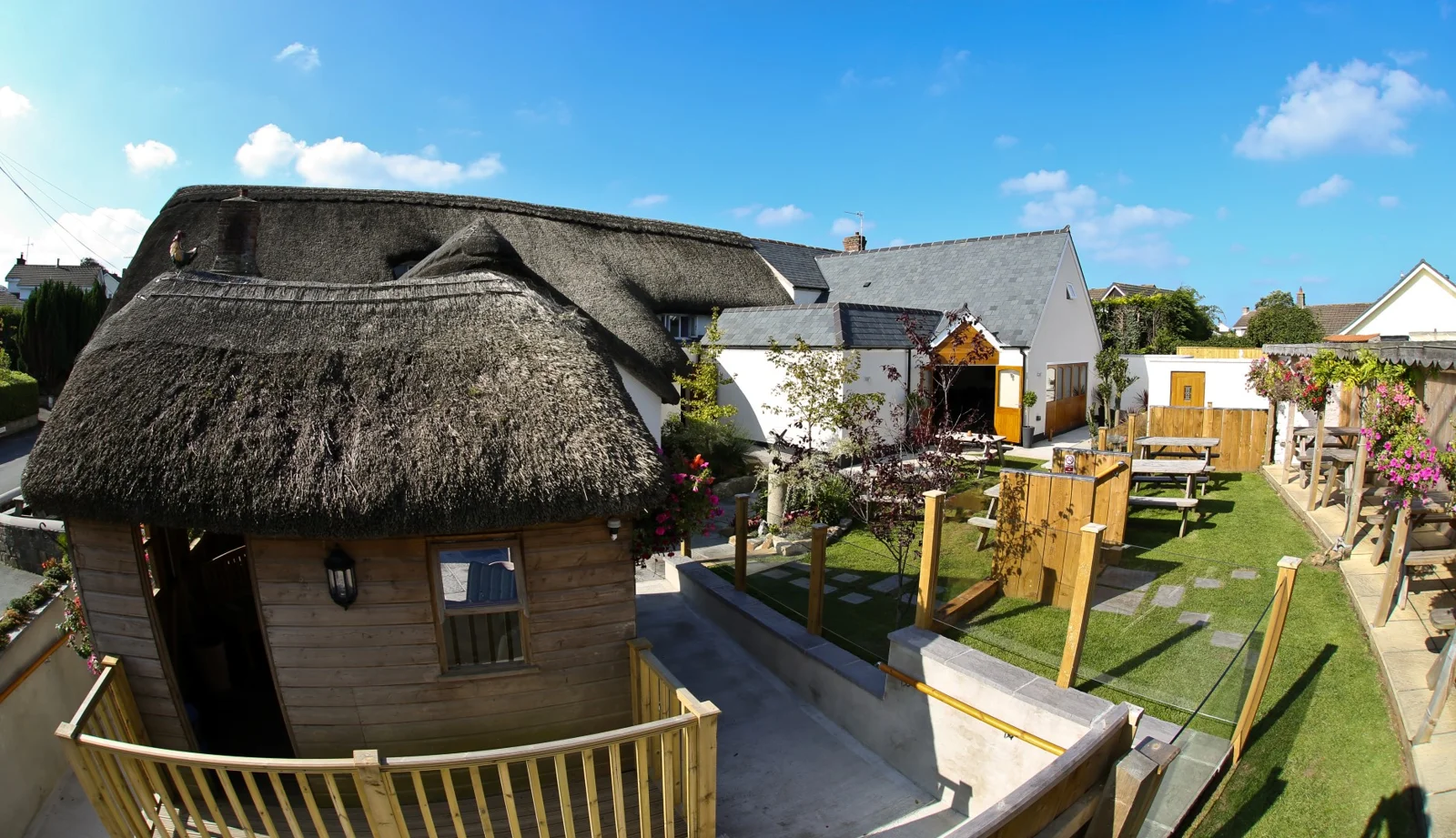 The Thatched Inn garden with lawn and picnic tables