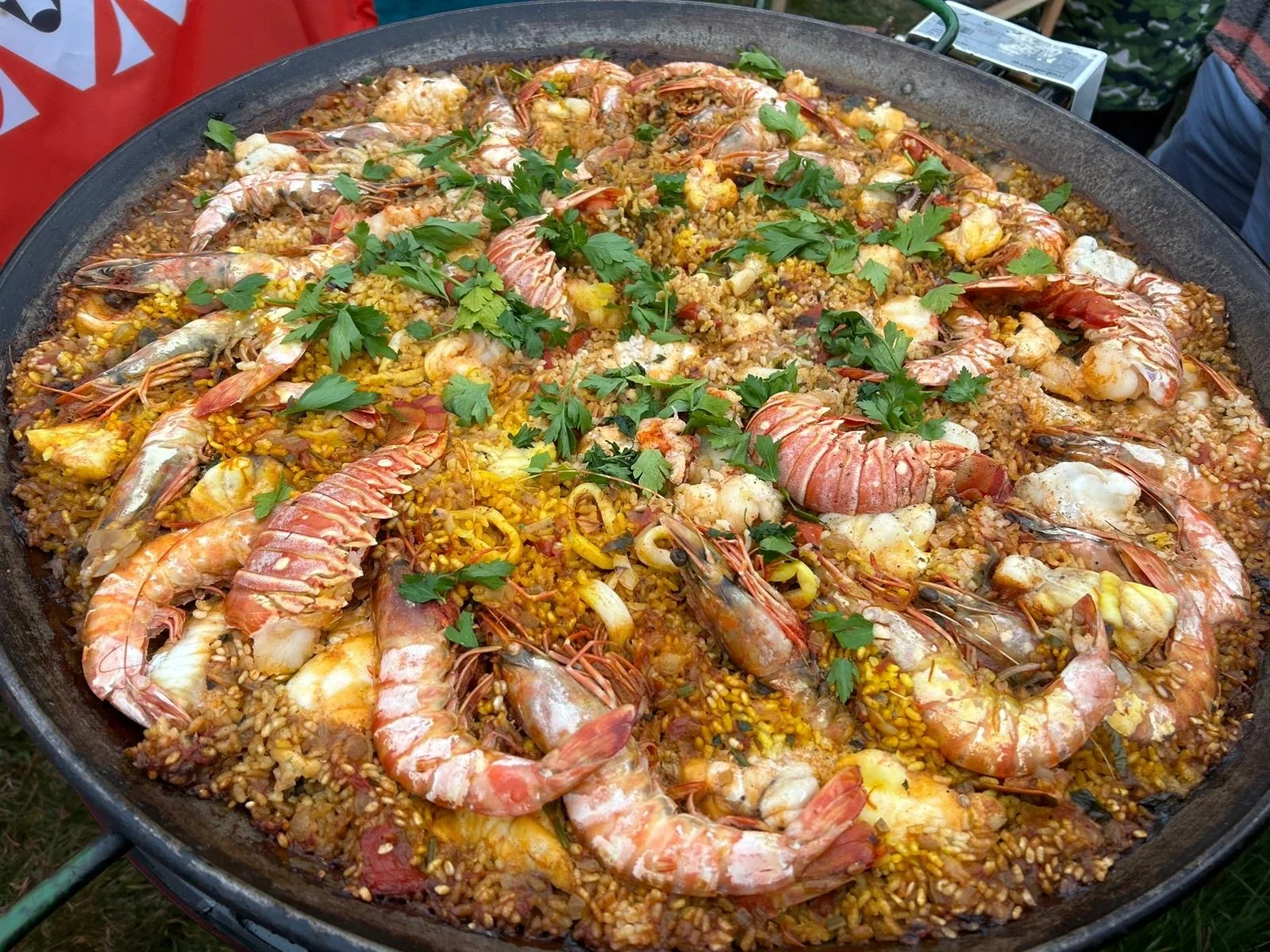 A large pan of paella with prawns and shellfish