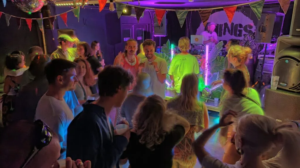 A colourful evening crowd enjoying music at Things Happen Here