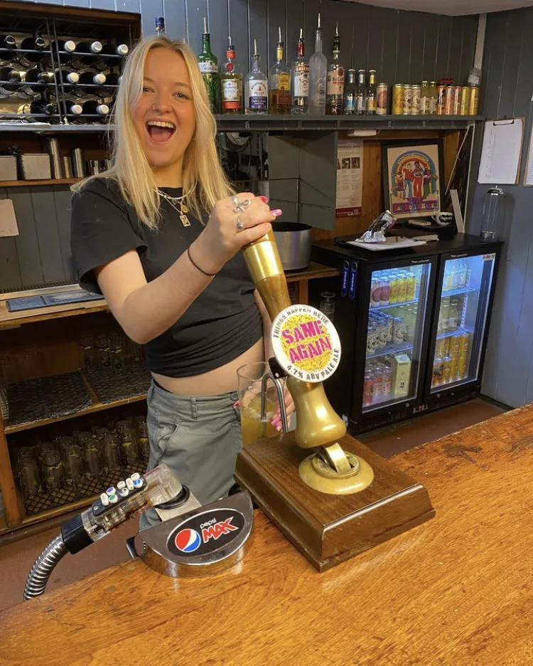 A smiling team member behind the bar at Things Happen Here