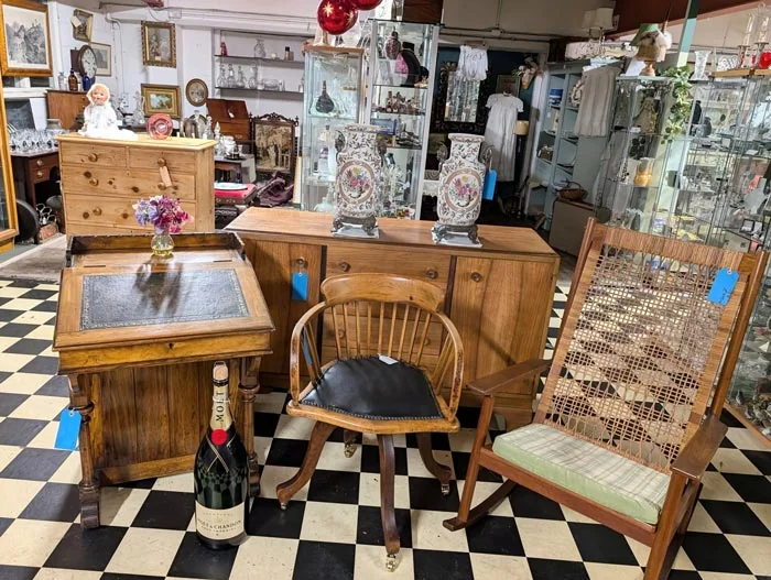 Antiques displays and furniture on a chequered floor inside the centre