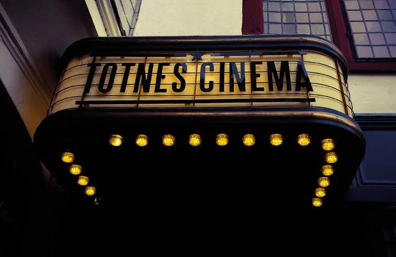 Illuminated Totnes Cinema entrance sign on High Street
