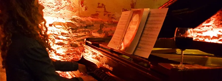 An upright piano against Totnes Cinema’s warmly lit stone wall