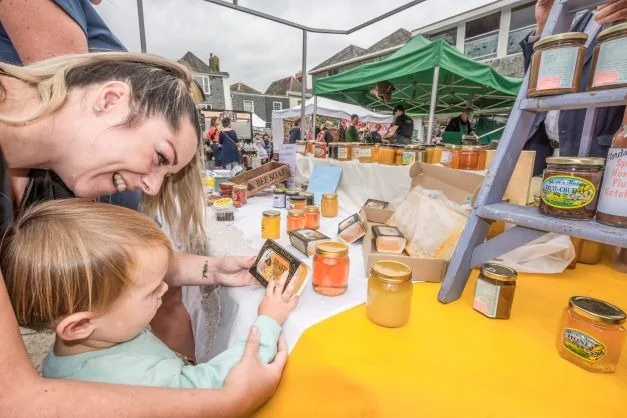 A family browsing jars at an outdoor market stall