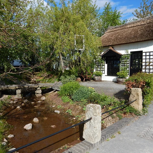 Stream and clapper bridge beside a miniature pub