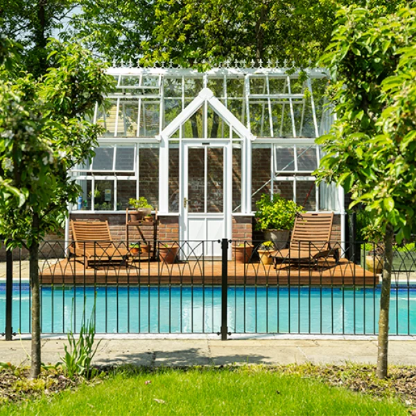 Glasshouse framed by leafy trees
