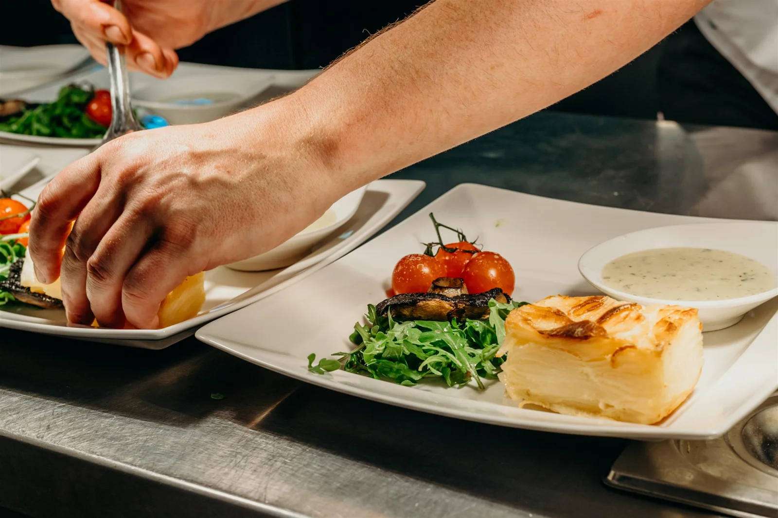 A chef plating steak and dauphinoise in the Turtley kitchen