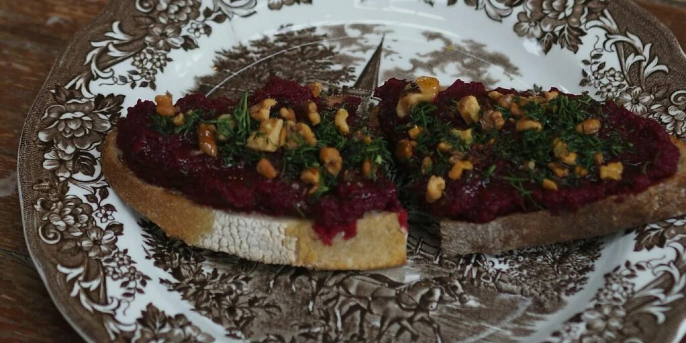Two topped slices of bread on a patterned plate