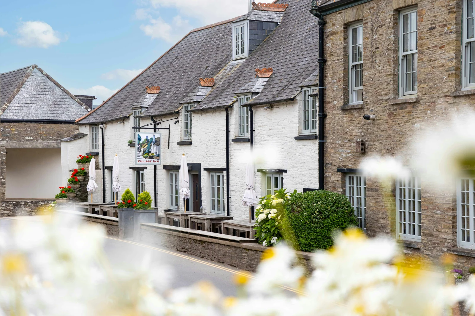 Whitewashed Village Inn beside stone buildings in Thurlestone