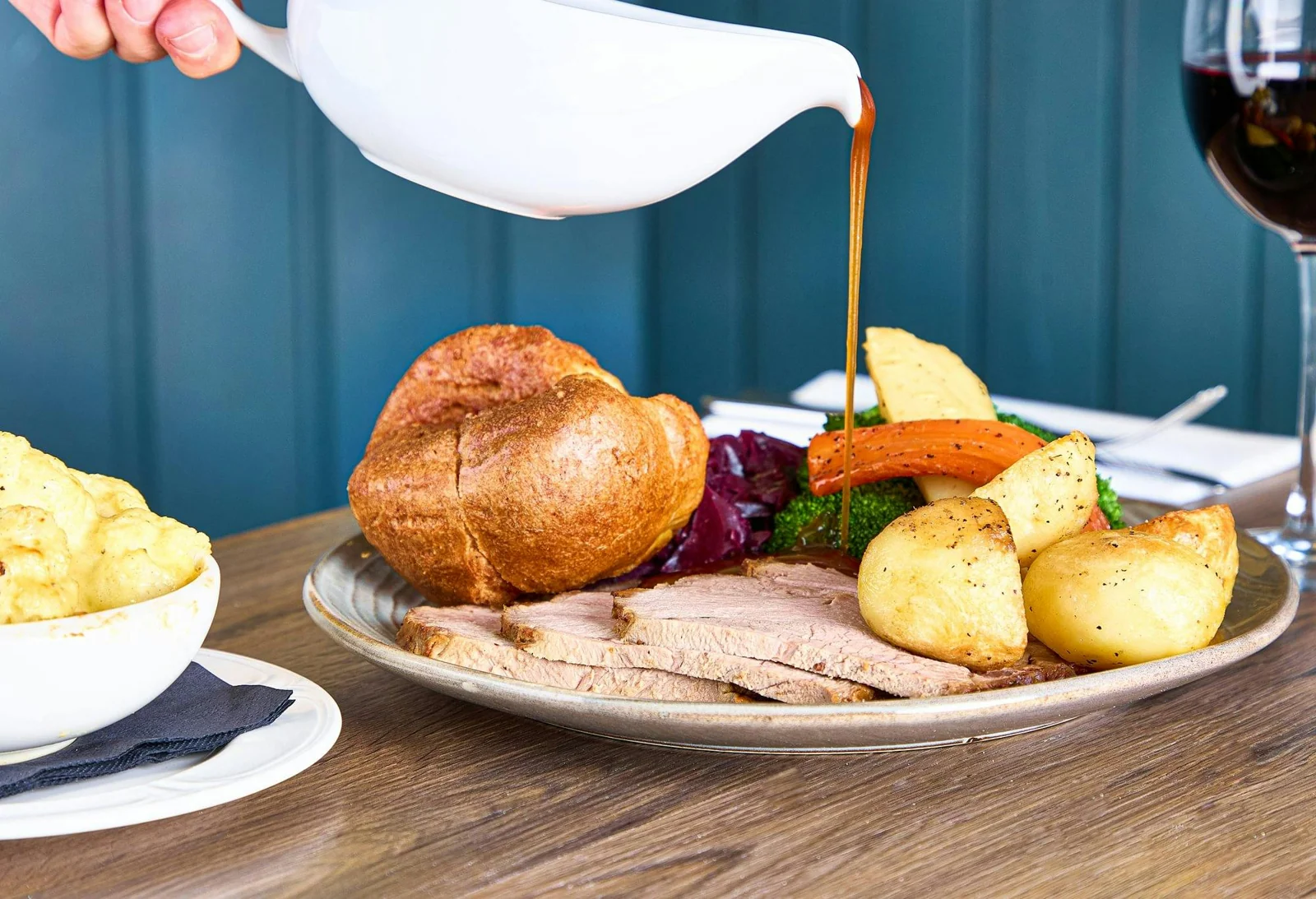 Gravy poured over a roast dinner with Yorkshire pudding