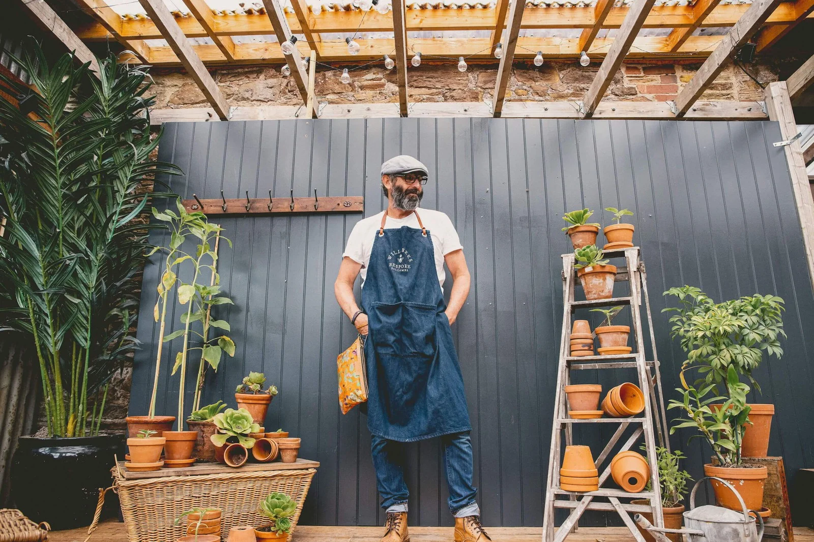 Will Bees wearing an apron beneath a timber workshop roof