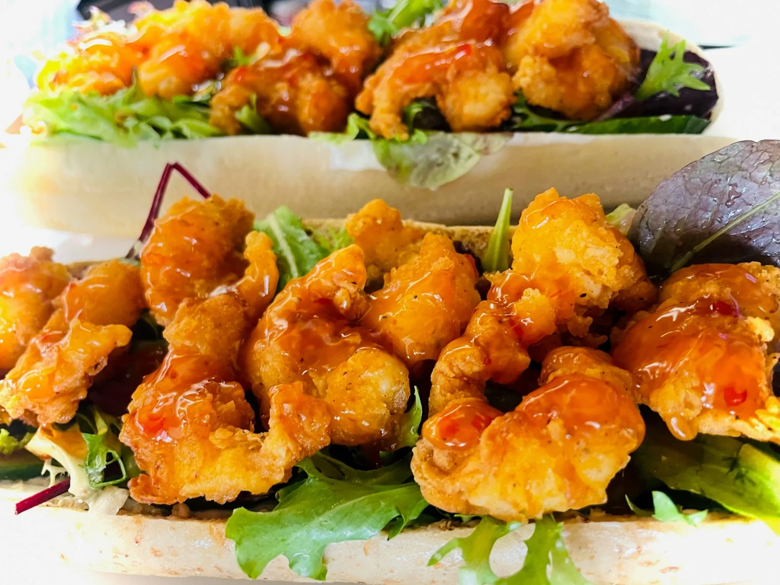 Golden fried shrimp served over salad
