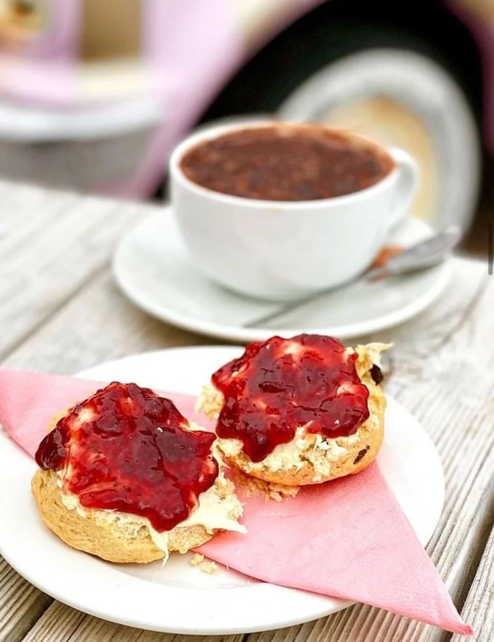 Scones with jam beside a cup of coffee