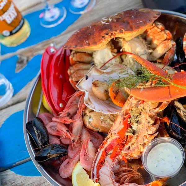 A seafood platter with crab, prawns, mussels and lobster on a blue table