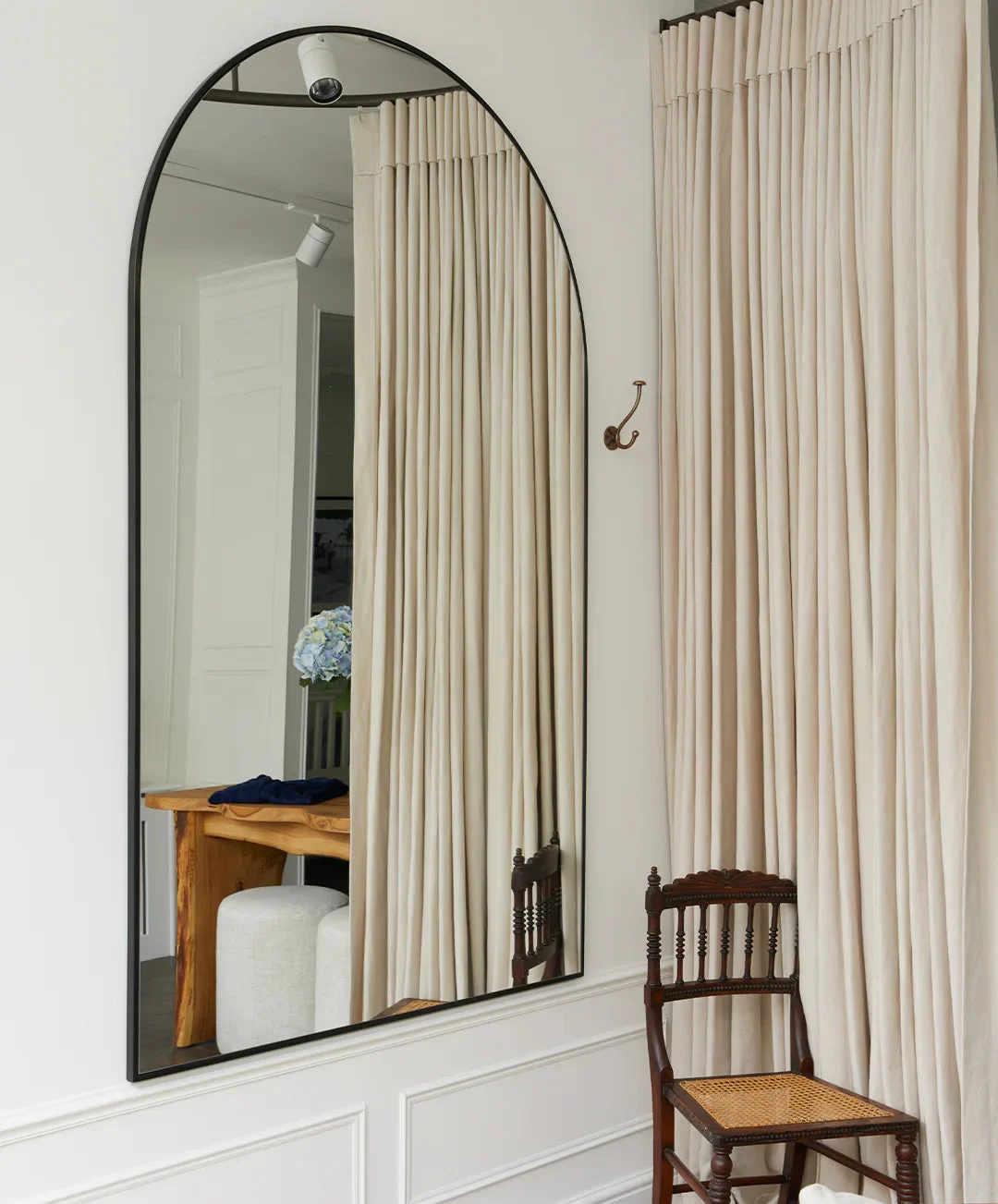 Interior of With Nothing Underneath’s Salcombe shop, with an arched mirror and fitting-room curtains